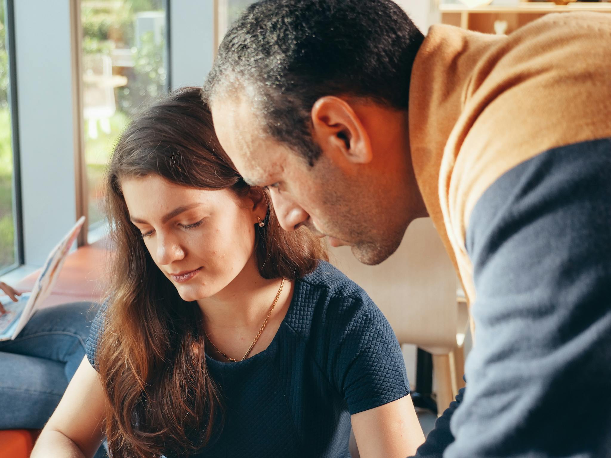 Two professionals engaged in a collaborative business discussion inside a well-lit office.